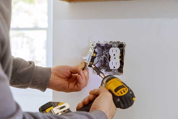 closeup of electrician changing a switch